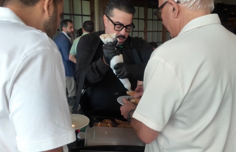 A cannoli being filled to order at an event